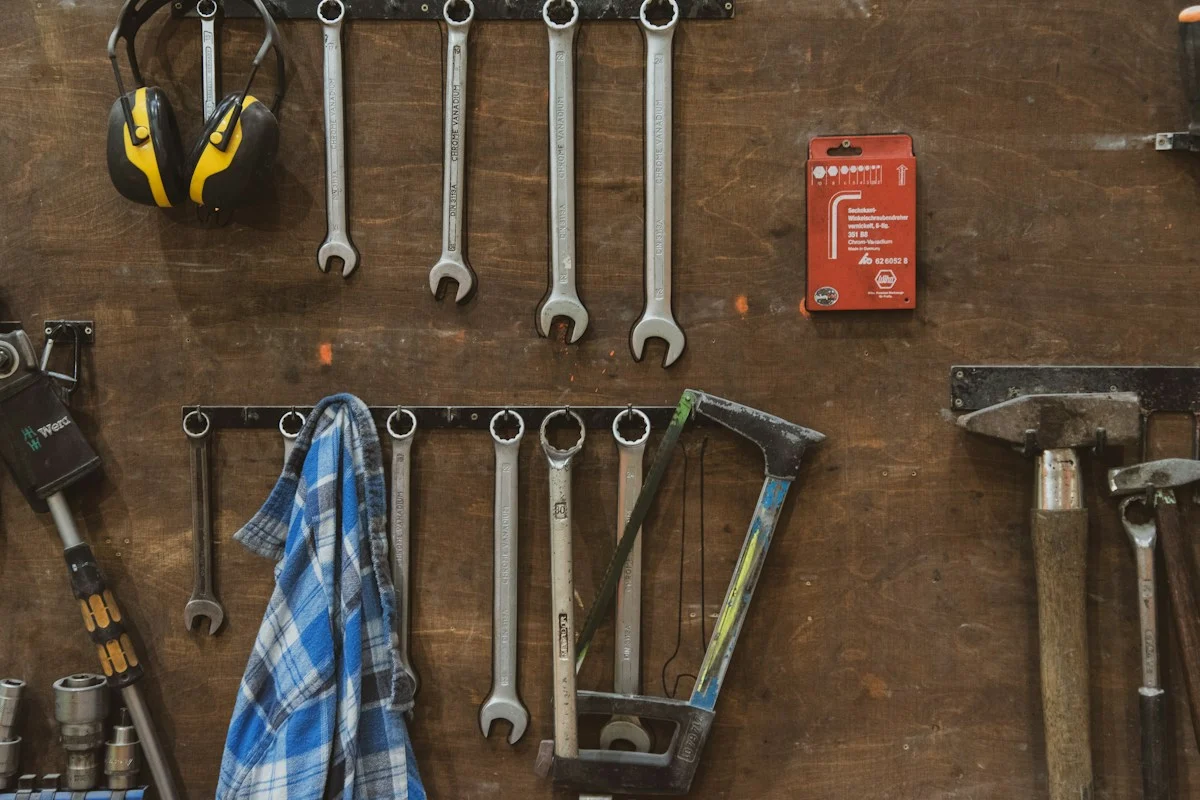 Wrenches and hand tools hanging on a workshop wall